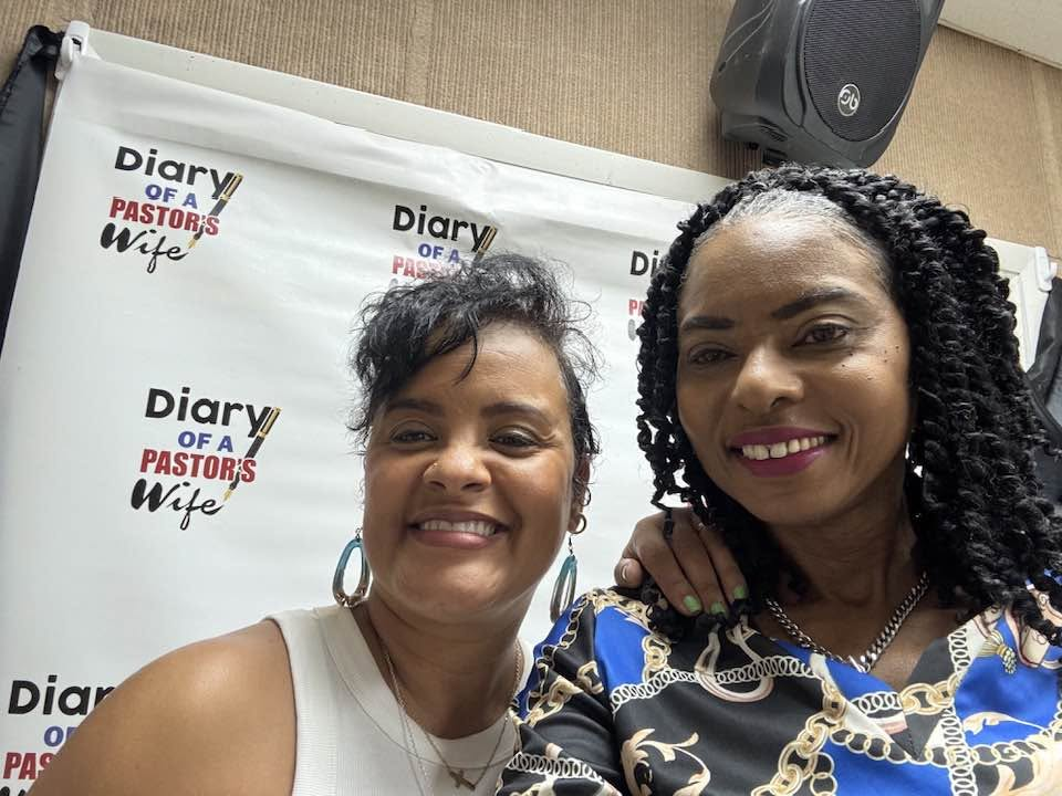 A shared smile at Diary Talk, with the book’s branded backdrop behind two women
